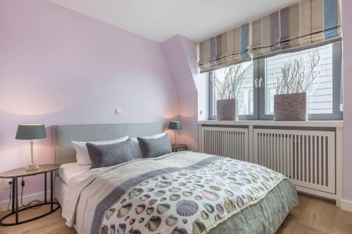 a bedroom with a large bed and a window at Lands-End in Hörnum