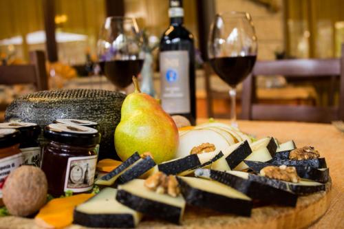 una mesa con un plato de comida y una copa de vino en Hotel Ristorante Tre Stelle en Montepulciano