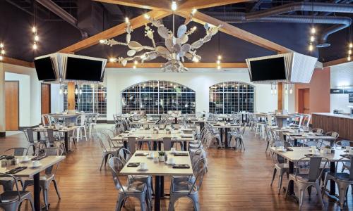 a dining room with tables and chairs and televisions at Holiday Inn Resort Mesquite by IHG in Mesquite