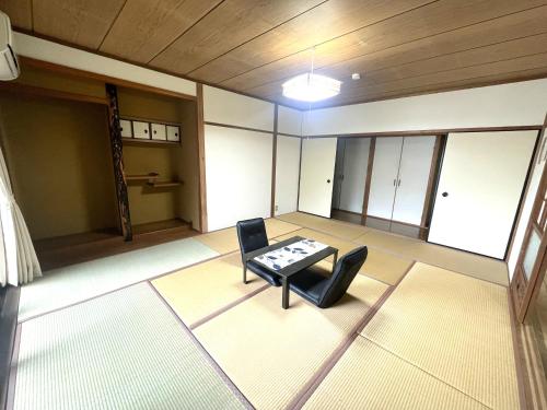 an empty room with a table and chairs at オーシャン日南らくだの宿 in Nichinan
