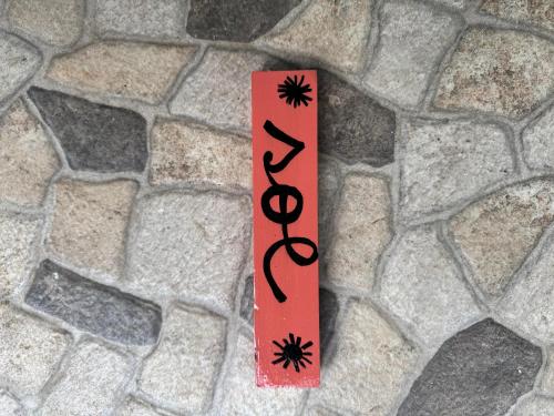 a sign on a stone wall with a spiderweb on it at Casa Nova at La Escapadita in Esterillos