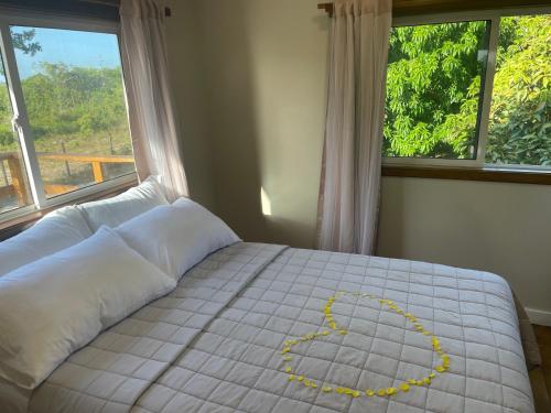 a bed with a heart drawn on it in a bedroom at K S G Cabanas in Dangriga
