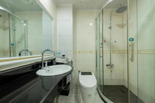 a bathroom with a toilet and a sink and a shower at Feng Hui Snow Mountain Resort Hotel Deqin Feilai Temple Branch in Shengping