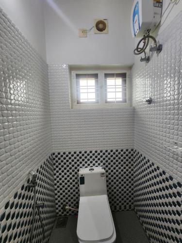 a bathroom with a toilet and a window at Happyhomes Homestay in Trivandrum