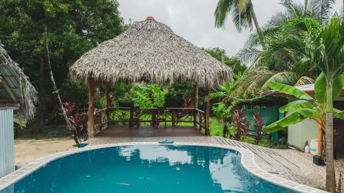 a resort with a swimming pool and a hut at Casa Nova at La Escapadita in Esterillos
