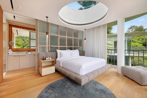 a bedroom with a bed and a large window at Bumi Kinar Skylight in Ubud