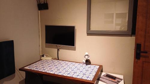 a room with a table with a tv on the wall at Suite Térrea Nova Campinas com ar e wi-fi in Campinas