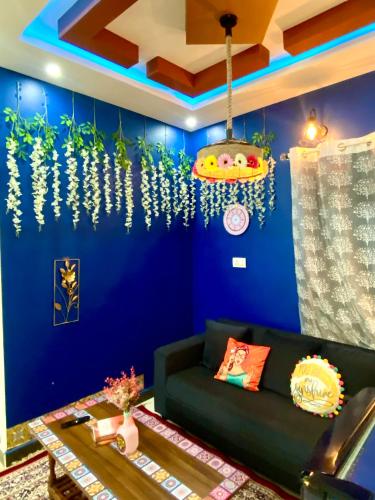 a living room with a couch and a blue wall at Villa De Dunes 369, Orchid Home in Bengaluru