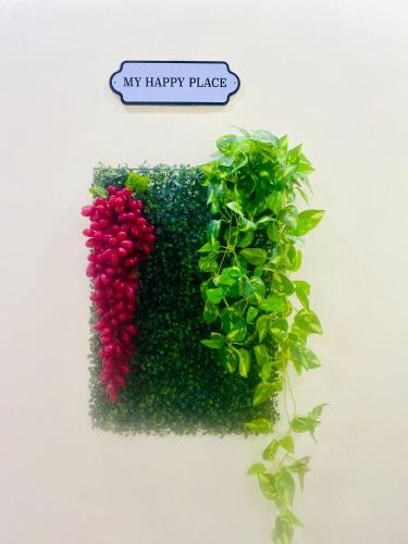 a green and red hedge with a sign that reads my happy place at Villa De Dunes 369, Orchid Home in Bengaluru