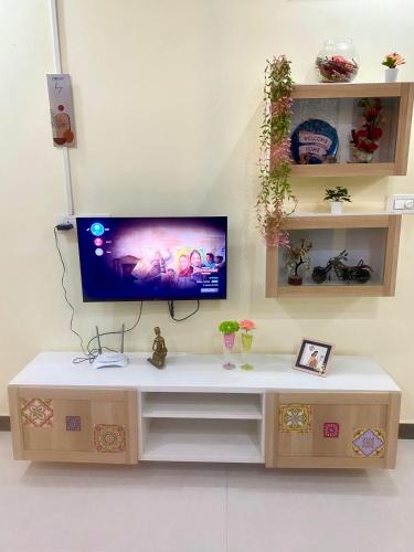 a tv sitting on top of a wooden entertainment center at Villa De Dunes 369, Orchid Home in Bengaluru