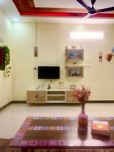 a living room with a television and a table at Villa De Dunes 369, Orchid Home in Bengaluru