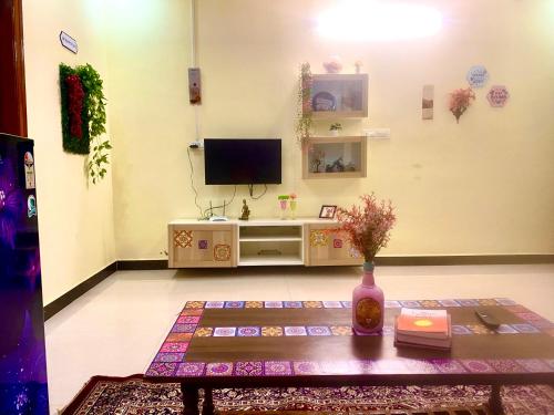 a living room with a tv and a table at Villa De Dunes 369, Orchid Home in Bengaluru