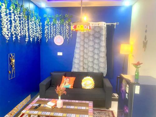 a living room with a couch and a blue wall at Villa De Dunes 369, Orchid Home in Bengaluru