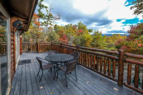 a patio with a table and chairs on a deck at Christines Cabin 1101 in Gatlinburg