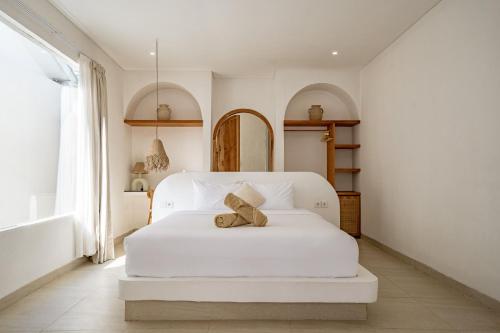 a bedroom with a white bed with a teddy bear on it at Villa Estrella Seseh in Cemagi