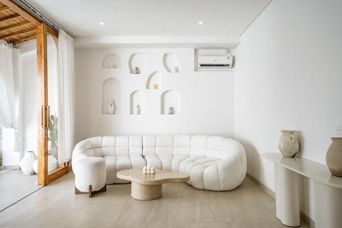 a living room with a white couch and a table at Villa Estrella Seseh in Cemagi