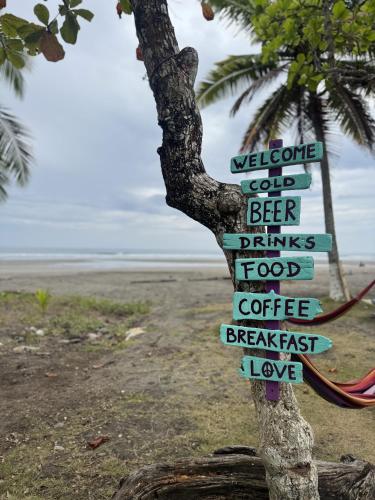 a sign attached to a tree on the beach at Casa Nova at La Escapadita in Esterillos