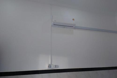 a white wall with a radiator in a room at Phnom Sampov Homestay ផ្ទះលំហែភ្នំសំពៅ in Phumĭ Kdaông Khang Tbong
