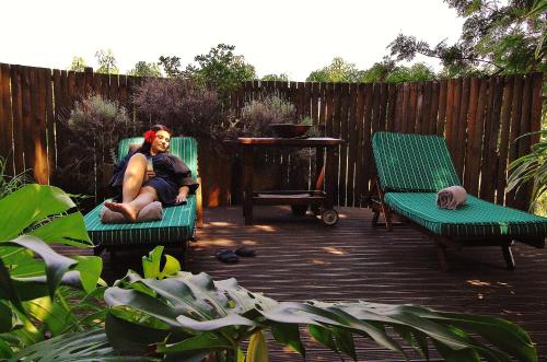 a man sitting in a chair on a patio at Tzaneen Country Lodge in Tzaneen