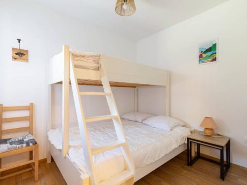 ein Schlafzimmer mit einem Etagenbett mit Leiter in der Unterkunft Appartement 5 personnes avec Wifi, parking, proche du lac à Génos - FR-1-695-78 in Génos
