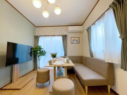 a living room with a couch and a table at Villa Kyoto Uzumasa East in Sagano