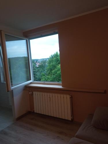a bedroom with a large window with a radiator at Kawalerka 30 metrów in Siemiatycze