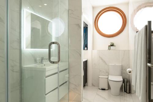 Un baño con inodoro, lavabo y espejo. en Fresh 1BR Apt Middle of CBD, en Gisborne