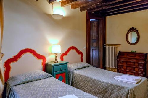 フィレンツェにあるCorno Florentine Apartment by 360Rentalsのベッドルーム1室(ベッド2台、ドレッサー、鏡付)