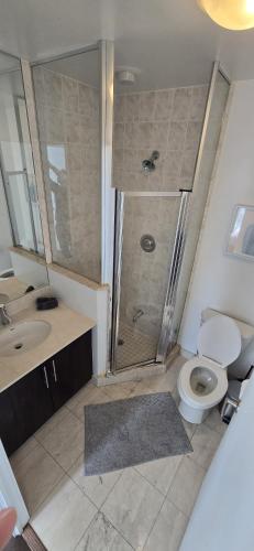 a bathroom with a shower and a toilet and a sink at Toronto CN Tower Maple Leaf Square Luxurious 2 Bedroom Condo in Toronto