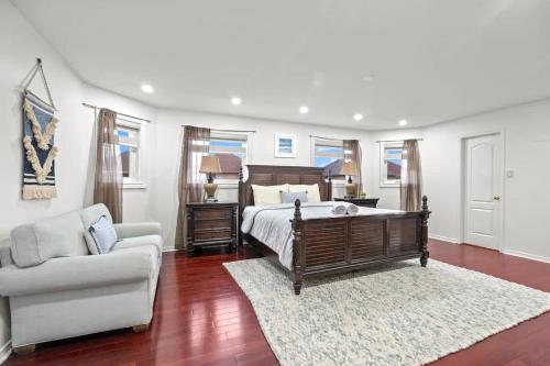 a bedroom with a bed and a couch and a chair at Elegant 5-Bedroom Family Home Patio & Fireplace in Mississauga