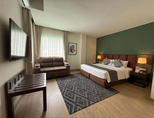 a hotel room with a bed and a couch at The Legacy Hotel Nana Sukhumvit, Aspira Collection in Bangkok