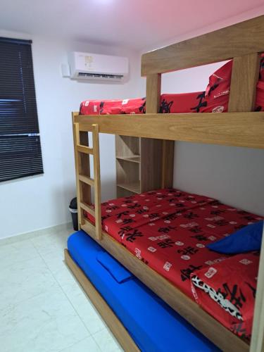a bunk bed in a room with a red blanket at Vacaciones Inolvidables in Coveñas