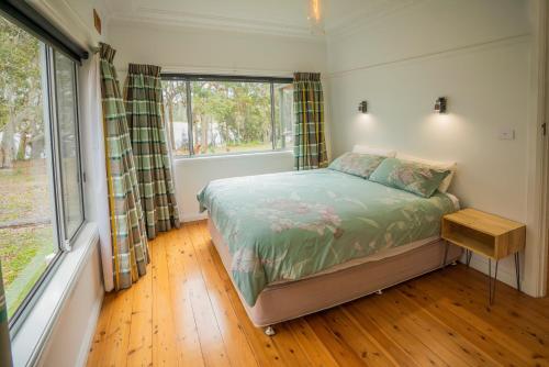 a small bedroom with a bed and a window at Yellow Rock in Benandarah