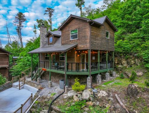 a wooden house with a wrap around porch at Big Bear Bend Gatlinburg Chalet Village in Gatlinburg