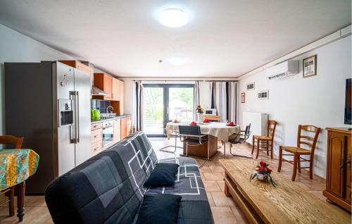 un salon avec un canapé bleu et une cuisine dans l'établissement Appartement Proche De La Meuse, à Chooz