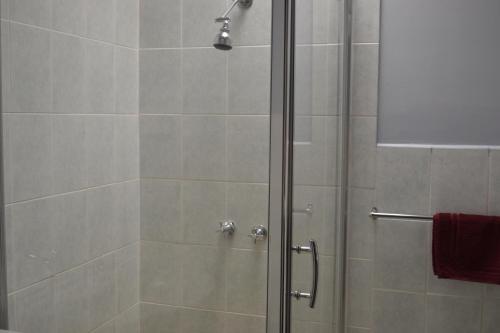 a shower with a glass door in a bathroom at Chadstone Executive Motel in Oakleigh
