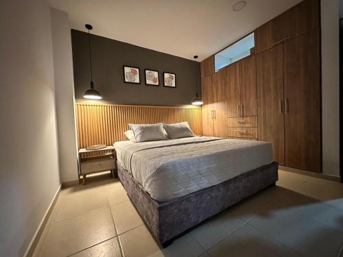 a bedroom with a large bed and wooden cabinets at Apartamento entero bien ubicado en zona exclusiva wifi in Popayan