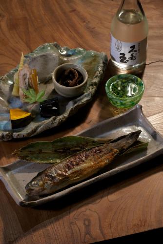 a plate of food with fish on a table at Minshuku Takizawa in Takayama