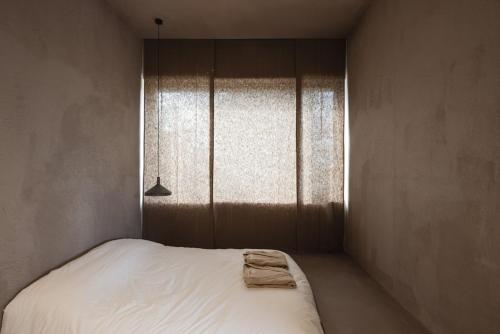 a bedroom with a white bed and a window at Jeju Monoha in Seogwipo