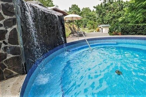 a swimming pool with an umbrella next to a stone wall at Malaga Herradura #25 with Private Pool in Herradura