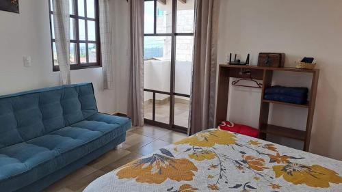 a living room with a blue couch and a bed at Casa Sac Nicte Tlalpujahua in Tlalpujahua de Rayón