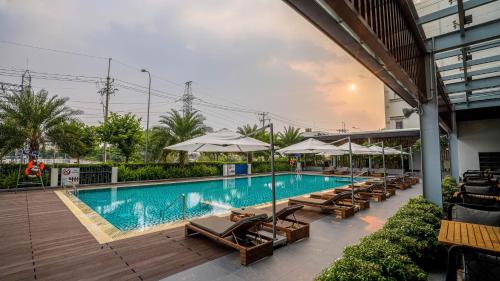 a swimming pool with lounge chairs and umbrellas at Fairfield by Marriott South Binh Duong in Thuan An