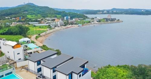 eine Luftansicht auf eine Stadt und einen Wasserkörper in der Unterkunft Ongjin Guardians Pool Villa in Sojang-gol