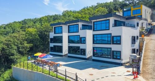 ein großes Gebäude mit vielen Fenstern in der Unterkunft Ongjin Guardians Pool Villa in Sojang-gol