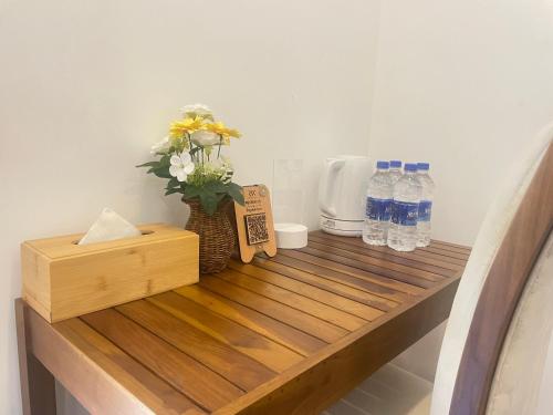 a wooden counter with bottles of water and flowers on it at RW Homestay in Wegala