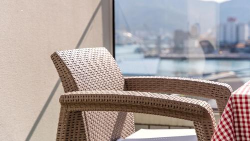 a wicker chair sitting on top of a balcony at Tongyeong Pension Present Pension in Tongyeong