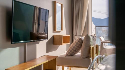 a living room with a flat screen tv on a wall at Tongyeong Pension Present Pension in Tongyeong