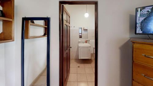 a hallway with a bathroom with a television and a bathroom at Rio Copey 2 near the beach in Jaco in Jacó