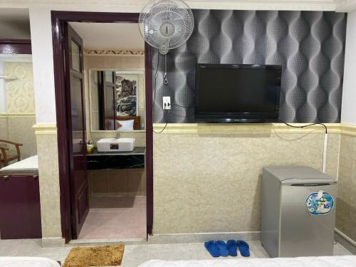 a living room with a television and a fan at Duc Long Airport Hotel in Ho Chi Minh City