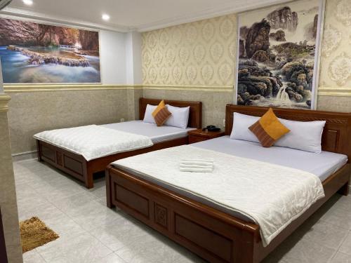 two beds in a hotel room with two bedsvisor at Duc Long Airport Hotel in Ho Chi Minh City
